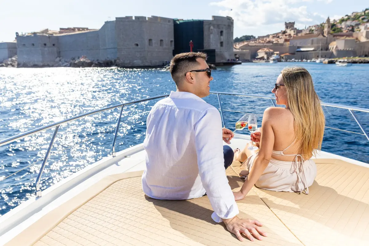 Couple toasting on the bow of Borna I in front of the Old Town