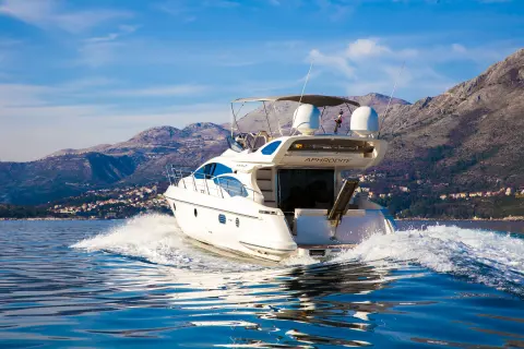 Flybridge motor yacht cruising along the coast