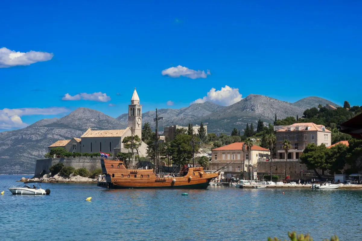 Lopud harbour with its monastery tower and a historic ship replica