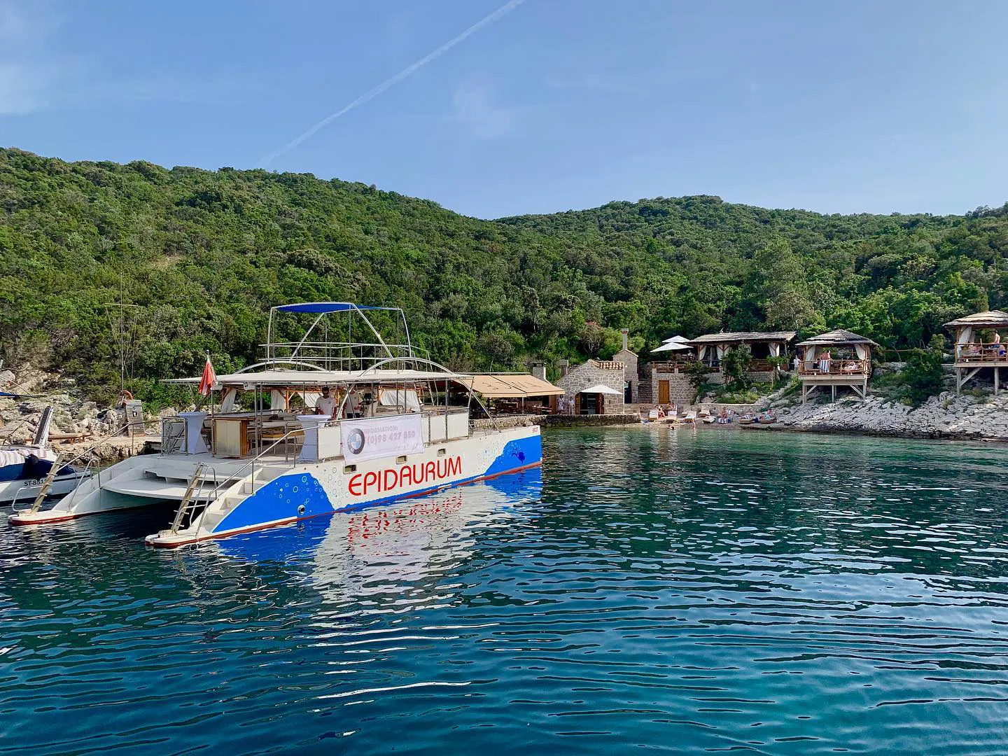 Epidaurum catamaran moored in a green island bay