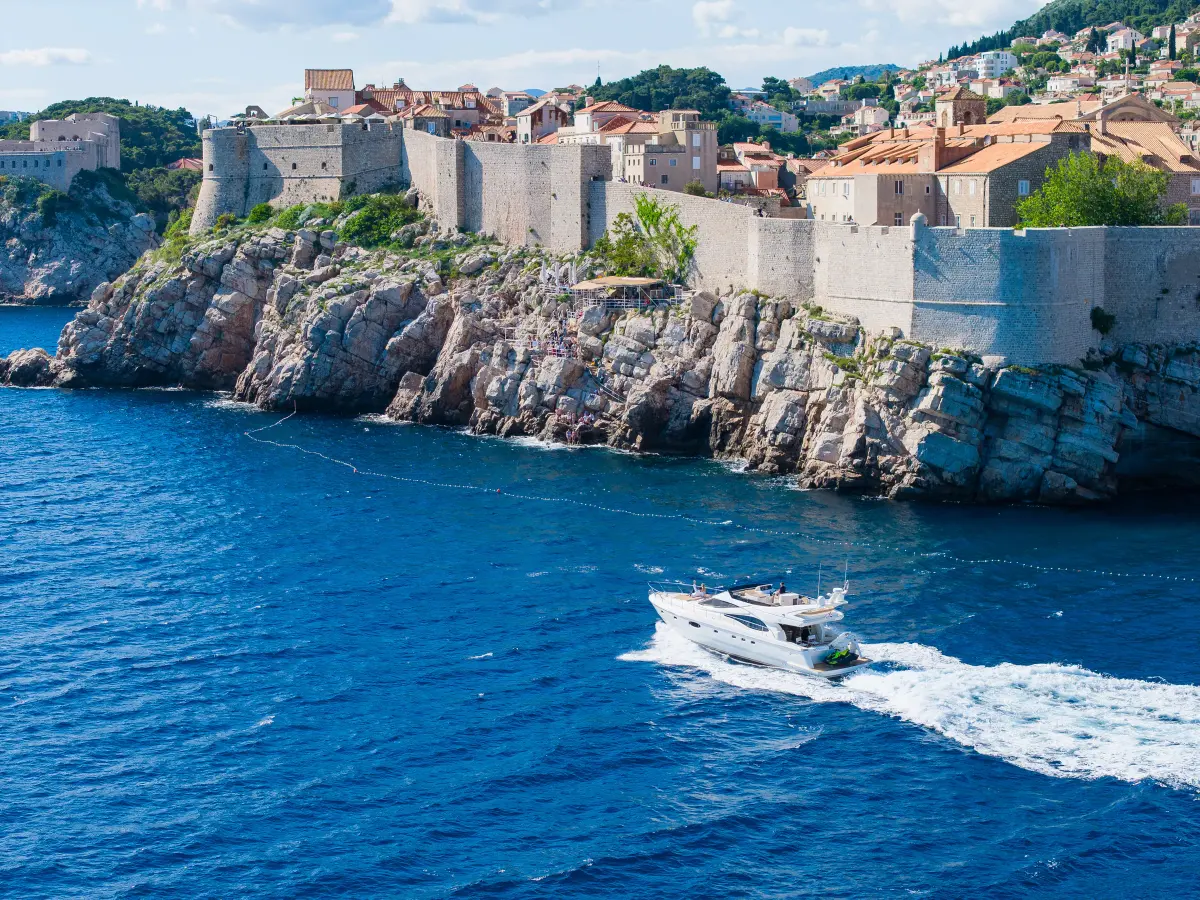 Motor yacht cruising beneath Dubrovnik's city walls