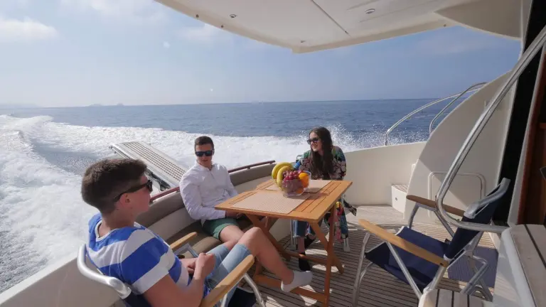 Guests at the aft-deck table of the Jeanneau Prestige 440 Fly