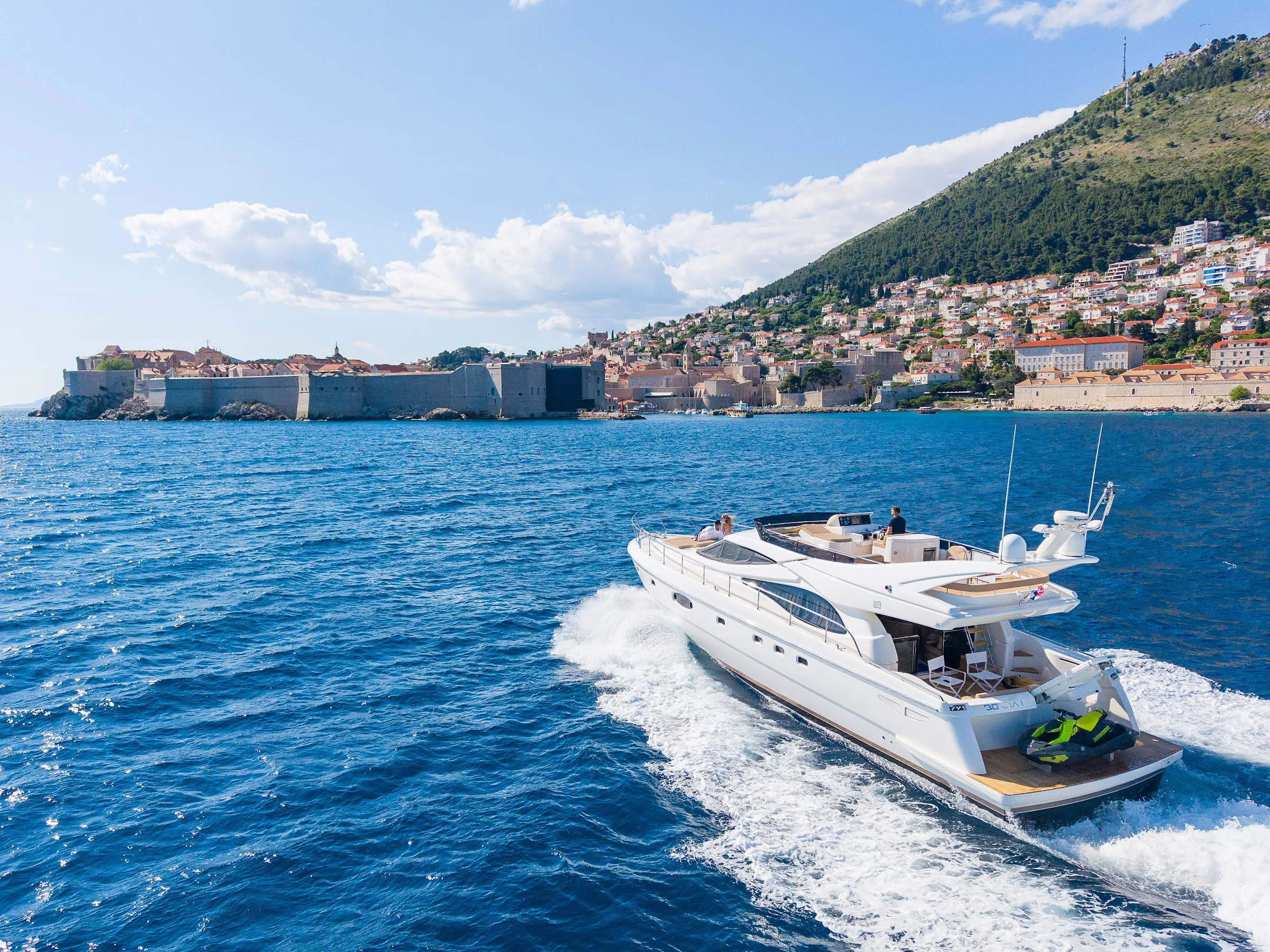 Ferretti motor yacht cruising past Dubrovnik Old Town